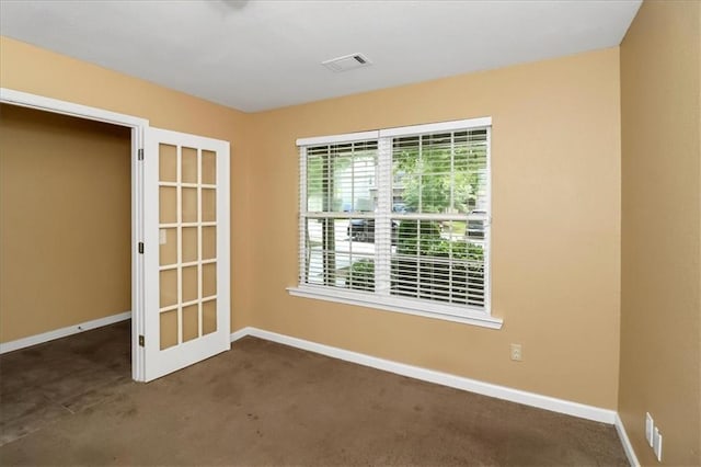 unfurnished room with visible vents, baseboards, and carpet