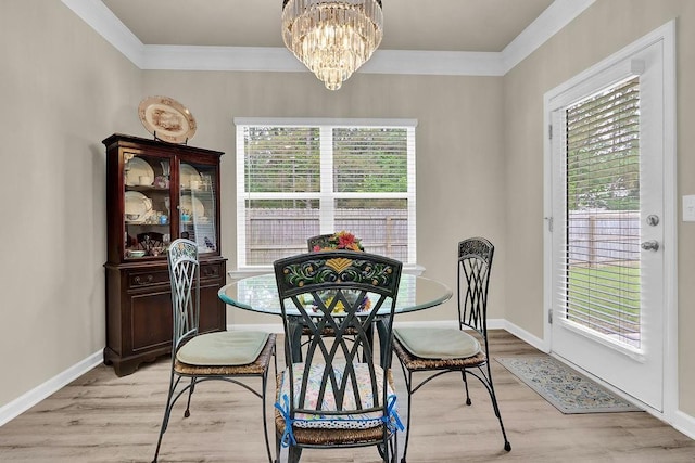 dining room featuring ornamental molding, plenty of natural light, light wood-type flooring, a chandelier, and baseboards