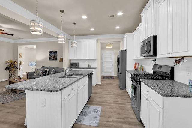 kitchen with appliances with stainless steel finishes, a sink, tasteful backsplash, white cabinetry, and recessed lighting