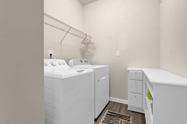 clothes washing area featuring separate washer and dryer, dark wood-style flooring, and baseboards