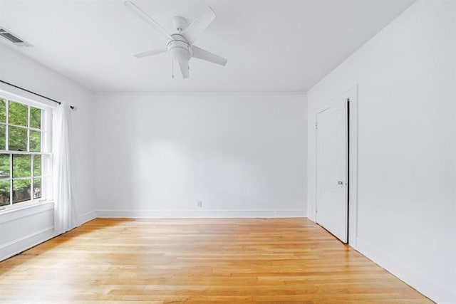 unfurnished room featuring light wood-style floors, baseboards, visible vents, and a ceiling fan