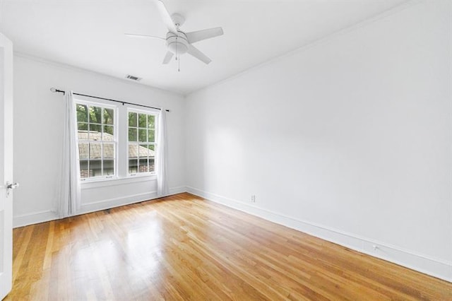 empty room with light wood-style floors, ceiling fan, visible vents, and baseboards