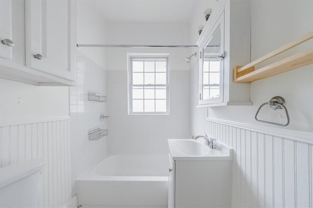 full bathroom with toilet, vanity, bathtub / shower combination, and wainscoting