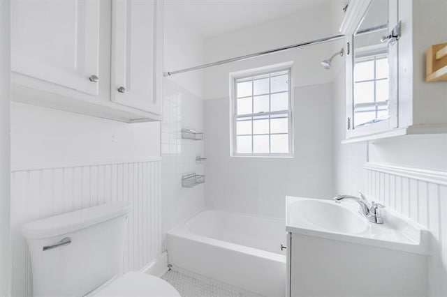 bathroom with shower / washtub combination, a wainscoted wall, plenty of natural light, and toilet