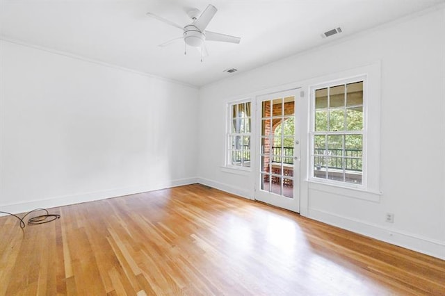 unfurnished room with a ceiling fan, baseboards, visible vents, and wood finished floors