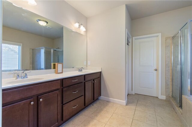 bathroom featuring tile patterned flooring, vanity, and a shower with shower door