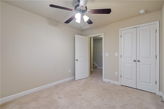 unfurnished bedroom with ceiling fan, light colored carpet, and a closet