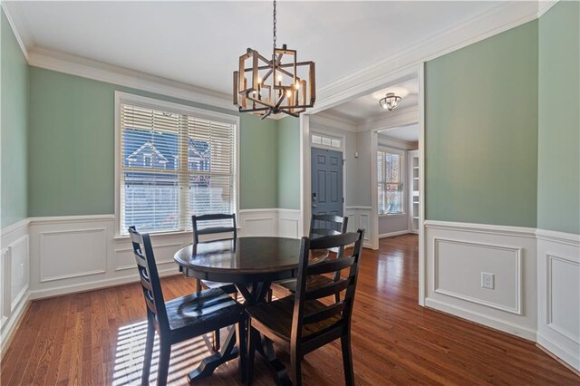 dining space with an inviting chandelier, dark wood-type flooring, crown molding, and a healthy amount of sunlight