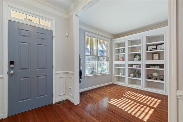 entrance foyer with dark wood-type flooring and ornamental molding