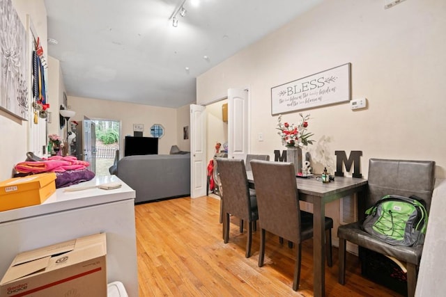 dining space with light wood-type flooring and rail lighting