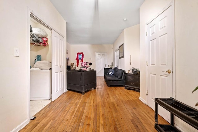 corridor featuring light wood-type flooring and baseboards