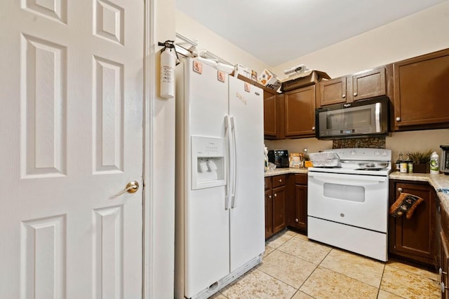 kitchen with light tile patterned floors and white appliances