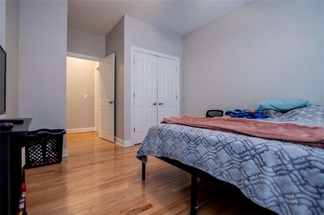 bedroom featuring a closet, baseboards, and light wood-style floors