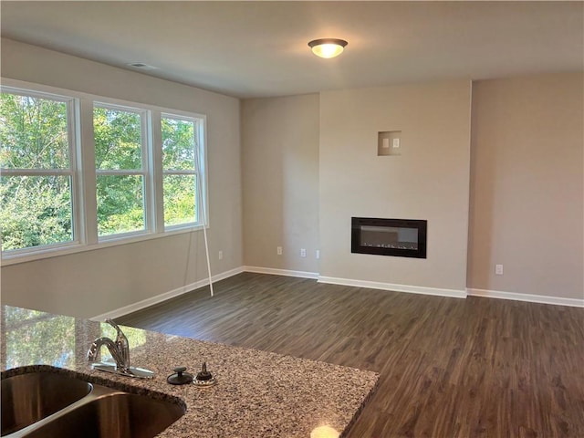 unfurnished living room with dark wood-type flooring and sink