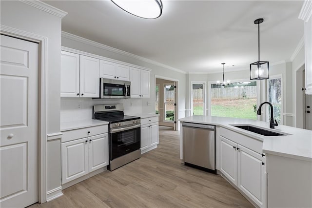 3807 Lance Bluff Ct, Duluth, GA 30097 - kitchen featuring appliances with stainless steel finishes, crown molding, white cabinets, light wood-type flooring, and light countertops