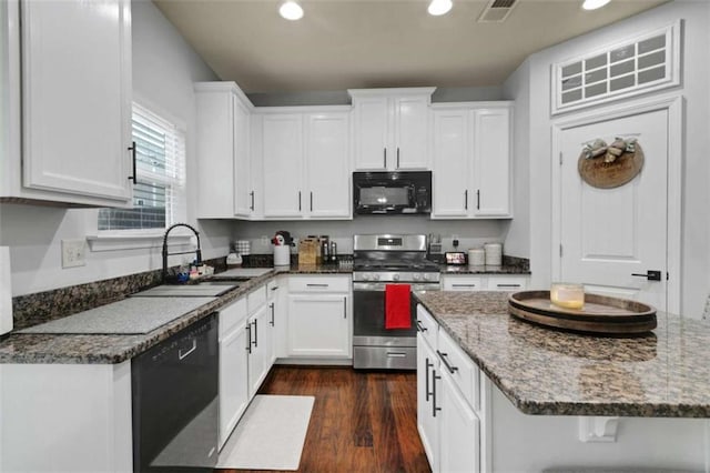 kitchen with white cabinetry, black appliances, visible vents, and a sink