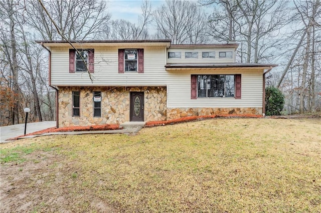 split level home featuring stone siding and a front lawn