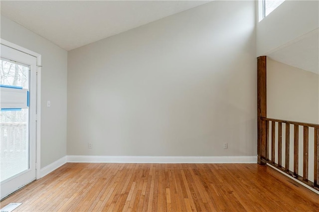 unfurnished room featuring light wood-type flooring, visible vents, and baseboards