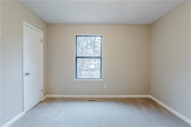 unfurnished room with light carpet and baseboards