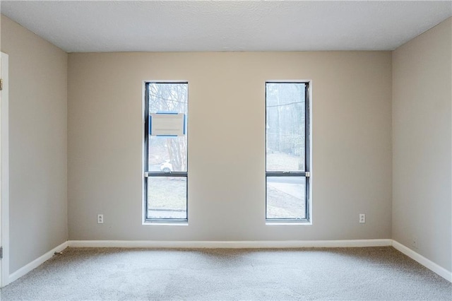 carpeted empty room with baseboards