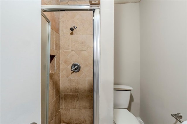 bathroom with a shower stall and toilet