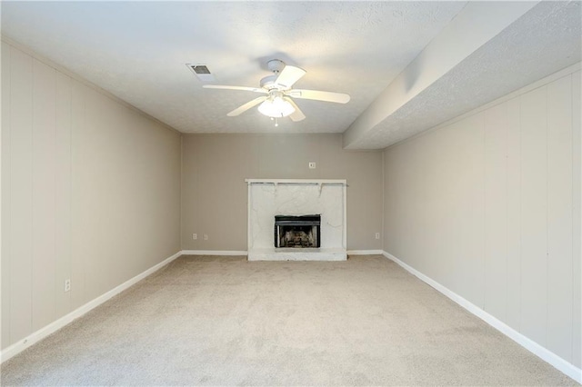 unfurnished living room featuring visible vents, baseboards, ceiling fan, carpet, and a high end fireplace