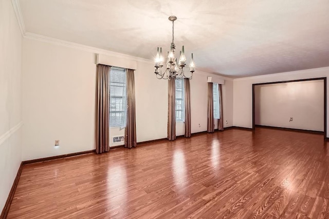 spare room with ornamental molding, hardwood / wood-style flooring, and a notable chandelier