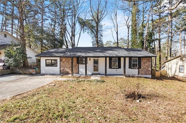 single story home with stone siding, a front lawn, and a porch