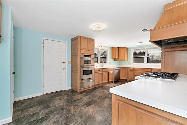 kitchen with appliances with stainless steel finishes, sink, light brown cabinetry, and custom exhaust hood