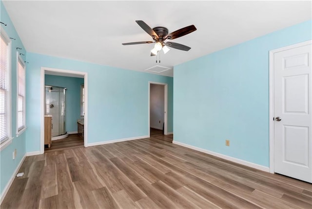 unfurnished bedroom featuring hardwood / wood-style flooring, ceiling fan, and ensuite bath