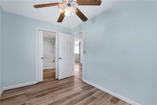 unfurnished bedroom with ceiling fan, a closet, and hardwood / wood-style flooring