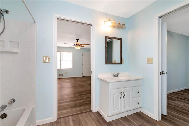 bathroom featuring ceiling fan,  shower combination, wood-type flooring, and vanity