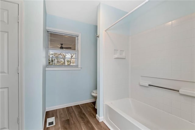 bathroom featuring wood-type flooring, toilet, and shower / bathtub combination