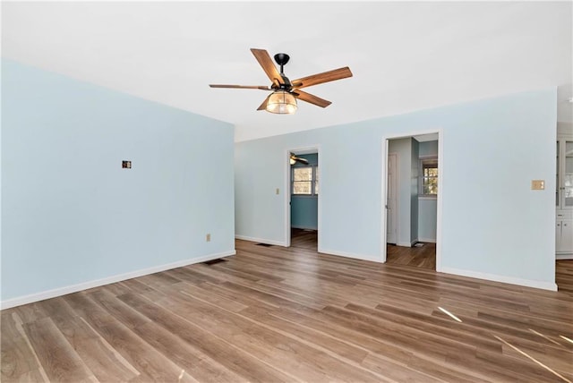 empty room with ceiling fan and hardwood / wood-style floors