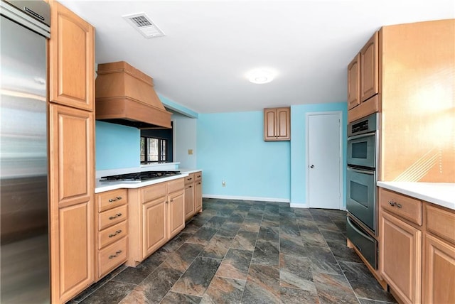 kitchen with custom range hood, light brown cabinets, and stainless steel appliances