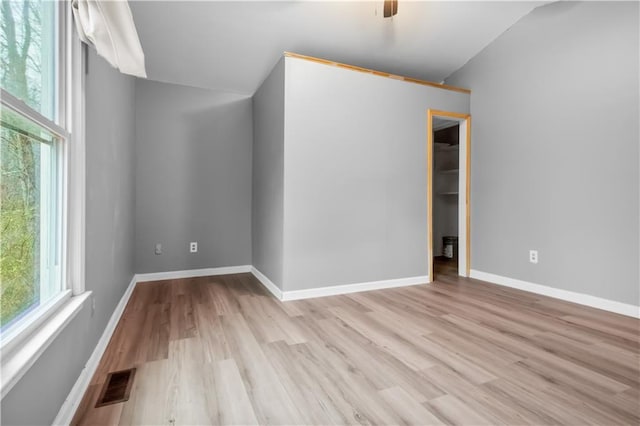 spare room featuring ceiling fan, plenty of natural light, and light hardwood / wood-style floors