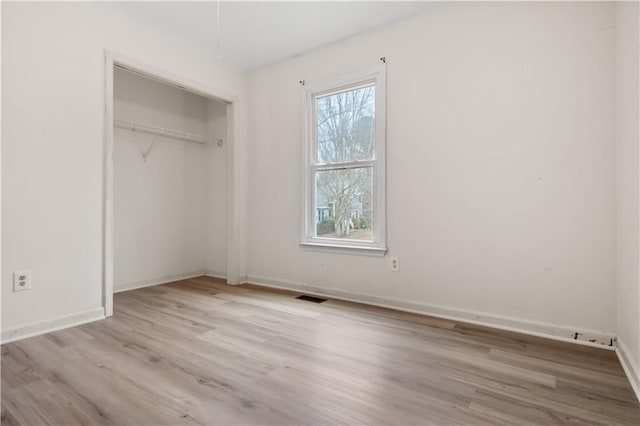 unfurnished bedroom featuring light wood-type flooring and a closet