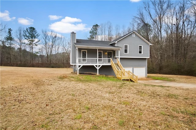 view of front of house featuring a porch, a garage, and a front yard