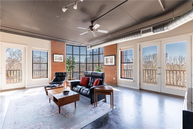 sunroom / solarium featuring ceiling fan, french doors, rail lighting, and visible vents