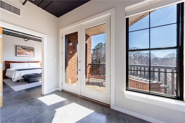 doorway with french doors, visible vents, finished concrete flooring, and baseboards