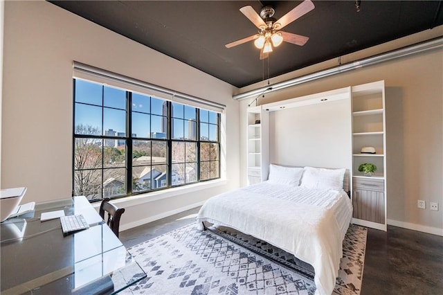 bedroom featuring concrete flooring and baseboards