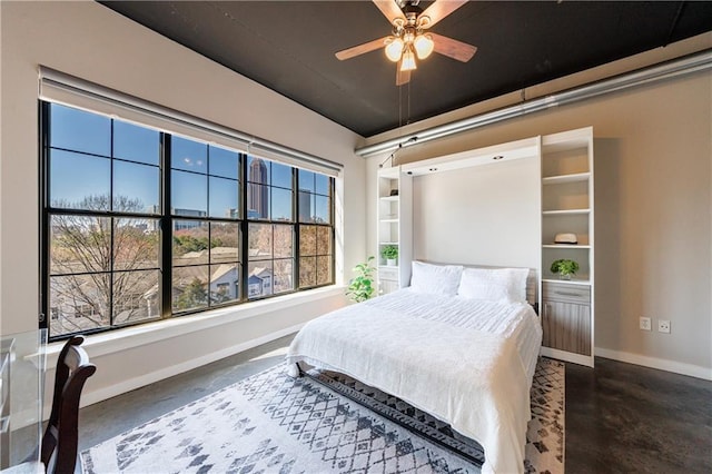 bedroom featuring concrete floors and baseboards