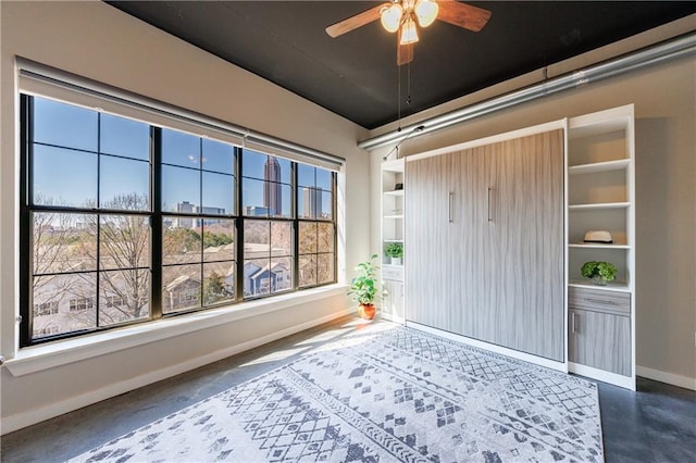 unfurnished sunroom featuring ceiling fan