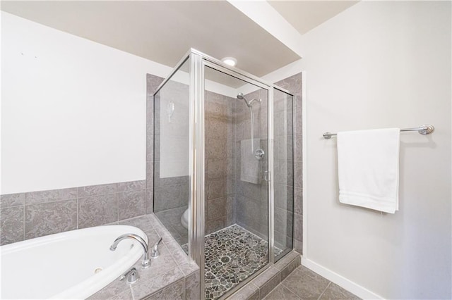 bathroom featuring tile patterned flooring, a garden tub, a shower stall, and toilet