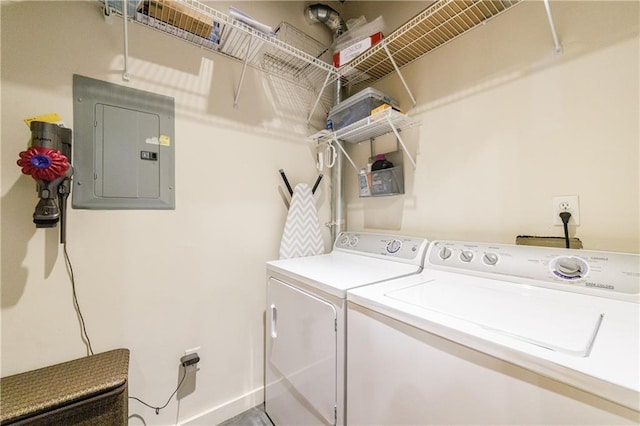 washroom featuring washing machine and dryer, laundry area, electric panel, and baseboards