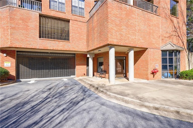 view of front of house with aphalt driveway, brick siding, and a garage