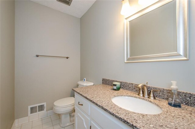 bathroom with vanity, tile patterned floors, and toilet