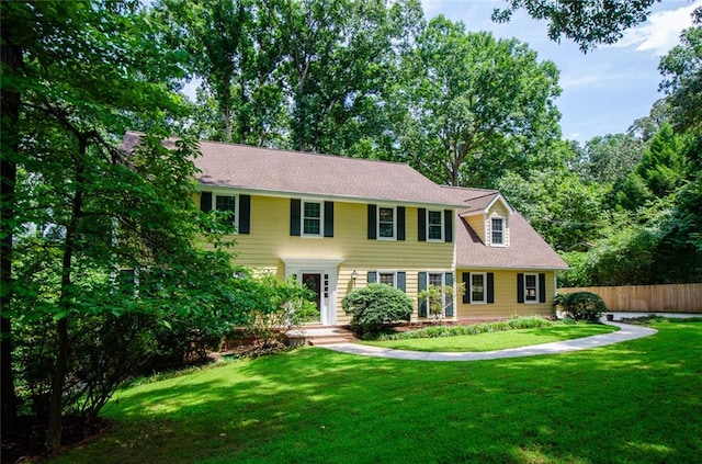 colonial-style house featuring a front lawn