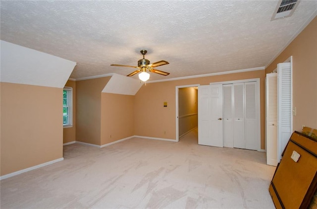 bonus room with lofted ceiling, light carpet, a textured ceiling, and ceiling fan