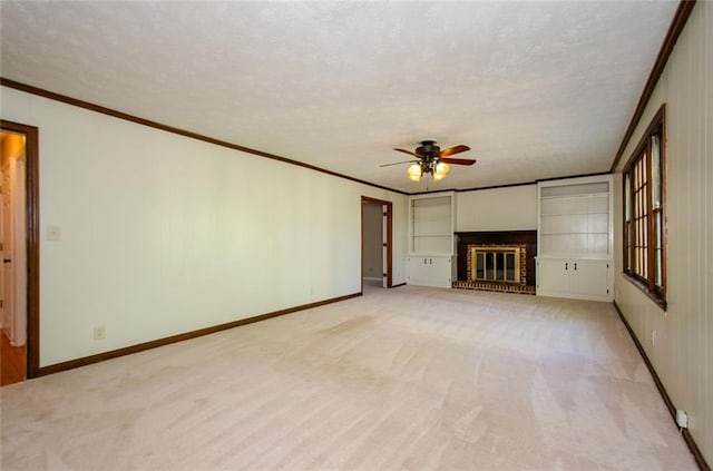 unfurnished living room with ceiling fan, ornamental molding, a textured ceiling, light carpet, and a brick fireplace